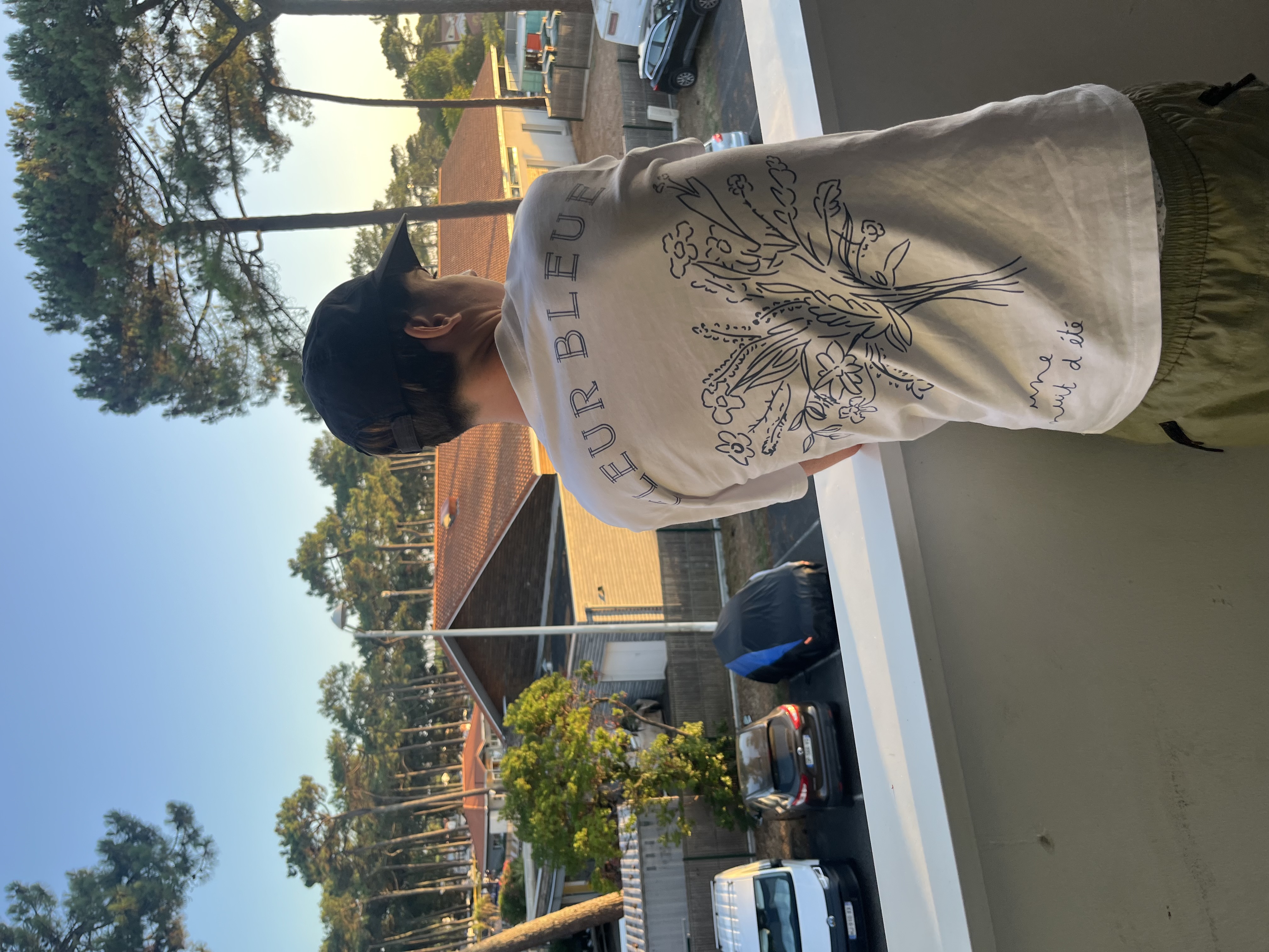 T-shirt Fleur Bleue vu de dos, sur un balcon